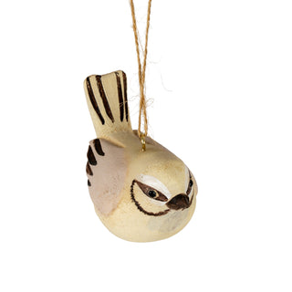 Close-up of the wooden bird decoration hanging, viewed from a steep angle, highlighting the painted face.