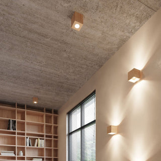 Interior scene with wooden quad lights mounted on concrete ceiling and used as wall lights.