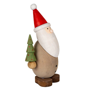 Wooden Santa decoration seen from the side, holding a small green tree with red dots.