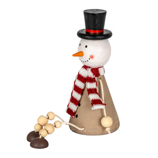 Wooden snowman decoration shown in profile, detailing the painted face and dangling wooden feet.