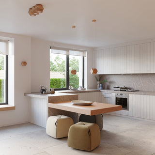 Two natural wood pendant lights hanging over a kitchen island in a bright, modern interior.